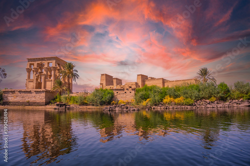 Incredible orange sunrise at the temple of Philae, a Greco-Roman construction seen from the Nile river, a temple dedicated to Isis, goddess of love. Aswan. Egyptian