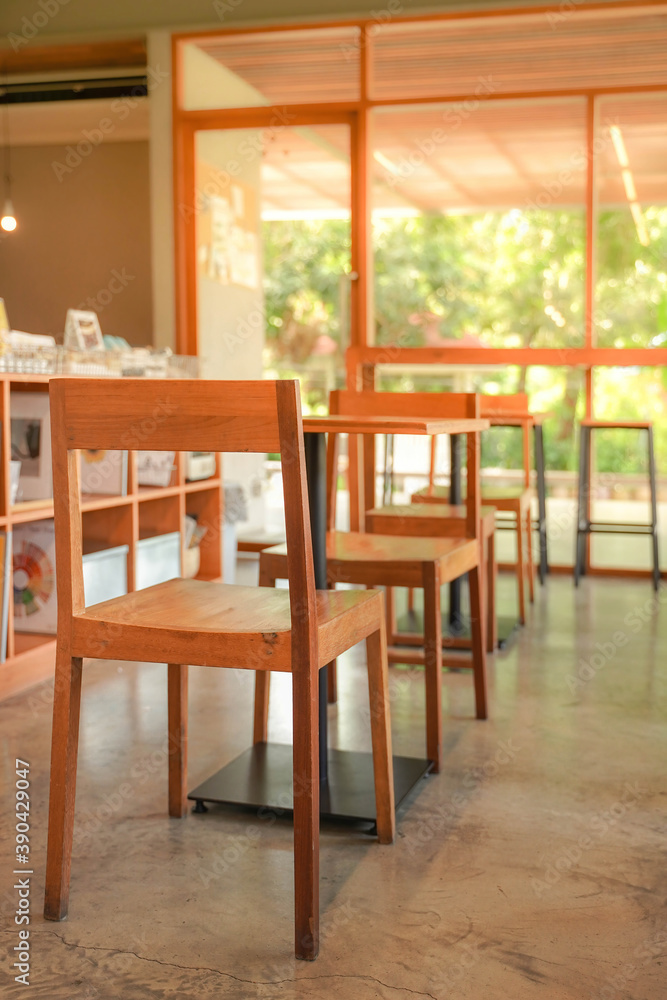 Fototapeta premium Cozy wooden interior of restaurant, copy space. Comfortable modern dining place, contemporary design background, available wooden chair andmetal table in canteen or cafe