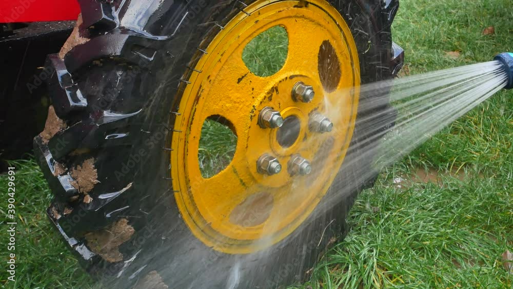 Wash truck wheels with a hose with water. Car wash. Wash the dirty ...