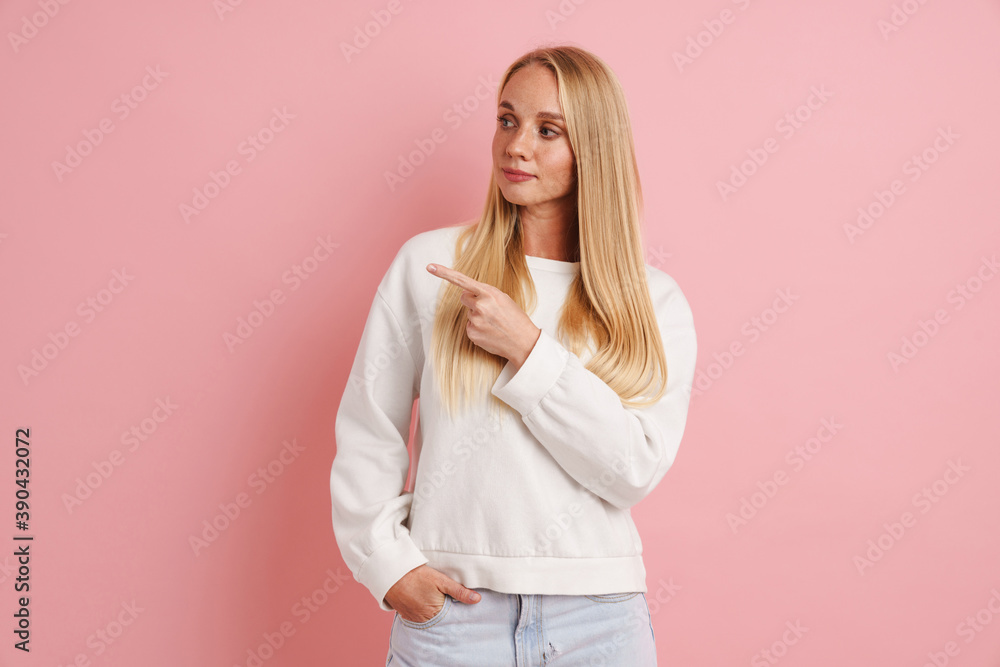 Caucasian beautiful girl looking and pointing finger aside Caucasian beautiful girl looking and pointing finger aside