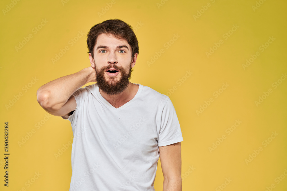 Man gesturing with hands emotions lifestyle white t-shirt yellow isolated background Man gesturing with hands emotions lifestyle white t-shirt yellow isolated background