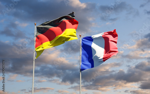 Beautiful national state flags of Germany and France together at the sky background. 3D artwork concept.