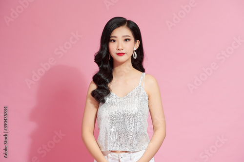 woman in elegant shiny dress on a pink background