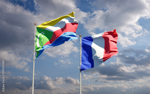 Beautiful national state flags of Comoros and France together at the sky background. 3D artwork concept.