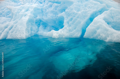 Detail of a bluish iceberg in clear water
