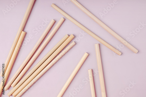 Bamboo straws straws on pink background.