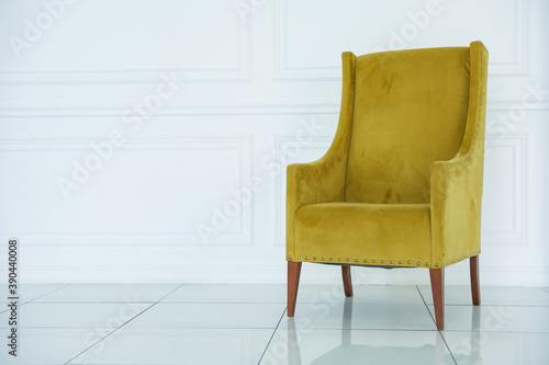 yellow soft armchair is in white room
