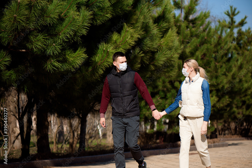 Fototapeta premium Young European man and woman in protective disposable medical mask walking outdoors afraid of dangerous NCoV 2019 influenza coronavirus mutated and spreading in China