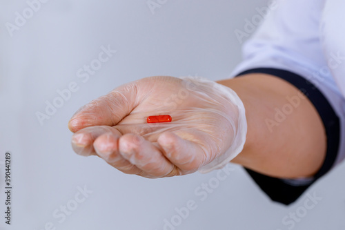 Doctor holding in pill in a hand isolated on white background