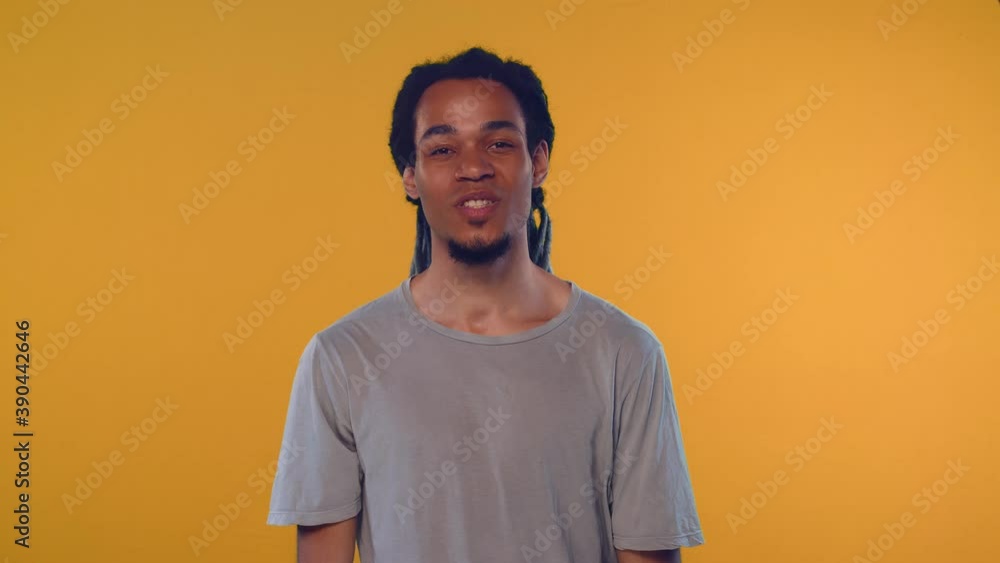 Indoor portrait of young good looking African American man has serious confident expression, feels angry after quarrel with colleagues, then has a kind expression, smiles. Indoor portrait of young good looking African American man has serious confident expression, feels angry after quarrel with colleagues, then has a kind expression, smiles.