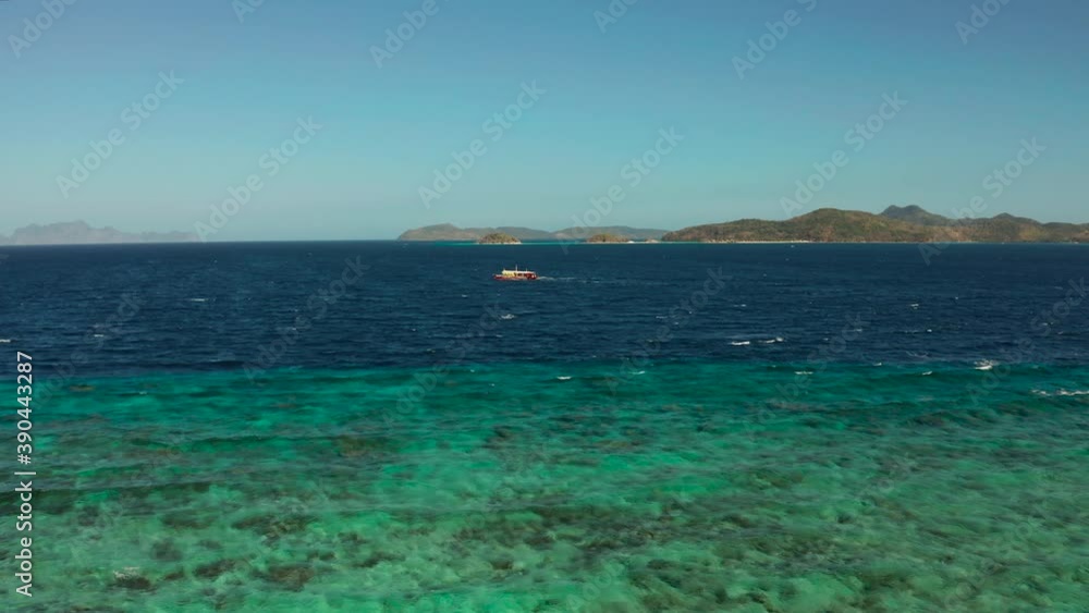 Aerial view tour boat in sea. Seascape blue sea and tropical islands. traditional Filipino wooden outrigger boat called a banca . Motorboat crossing ocean. Banca boat in the Philippines Palawan Aerial view tour boat in sea. Seascape blue sea and tropical islands. traditional Filipino wooden outrigger boat called a banca . Motorboat crossing ocean. Banca boat in the Philippines Palawan