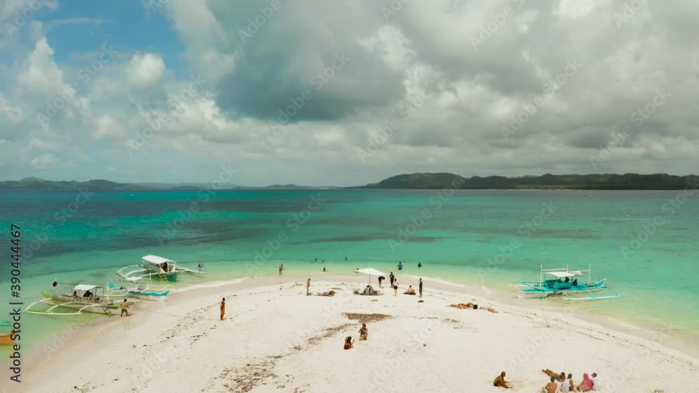 Sandy beach with tourists among turquoise waters and coral reefs. Beach at the atoll. Summer and travel vacation concept. Naked Island, Siargao. Sandy beach with tourists among turquoise waters and coral reefs. Beach at the atoll. Summer and travel vacation concept. Naked Island, Siargao.