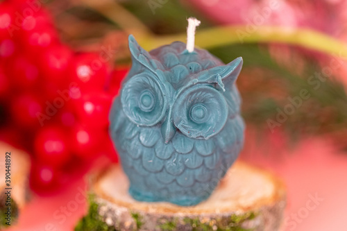 Handmade honey candles made of natural wax in the form of owl on a pink background. Elements from natural materials. Christmas or New Year composition. Photo for postcards.