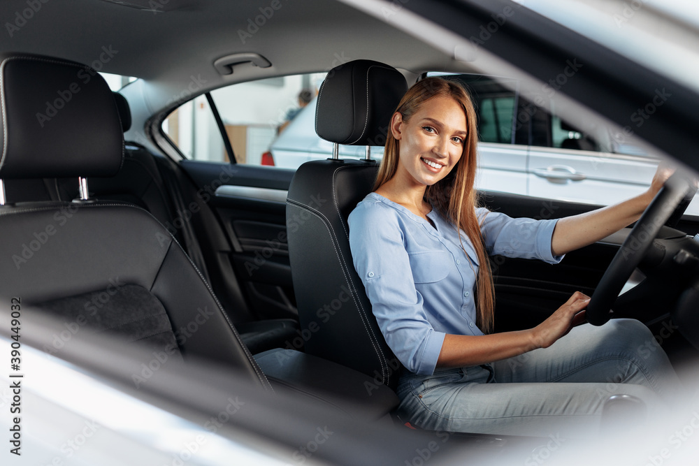 Happy woman new car owner sitting in driver seat