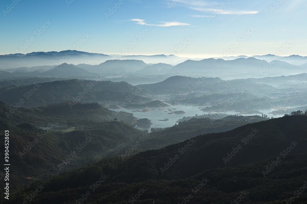 Fresh foggy mountain landscape on sunrise. View to valley with the Maskeliya reservoir Adam's Peak (also known as Sri Pada) in the morning. Sri Lanka