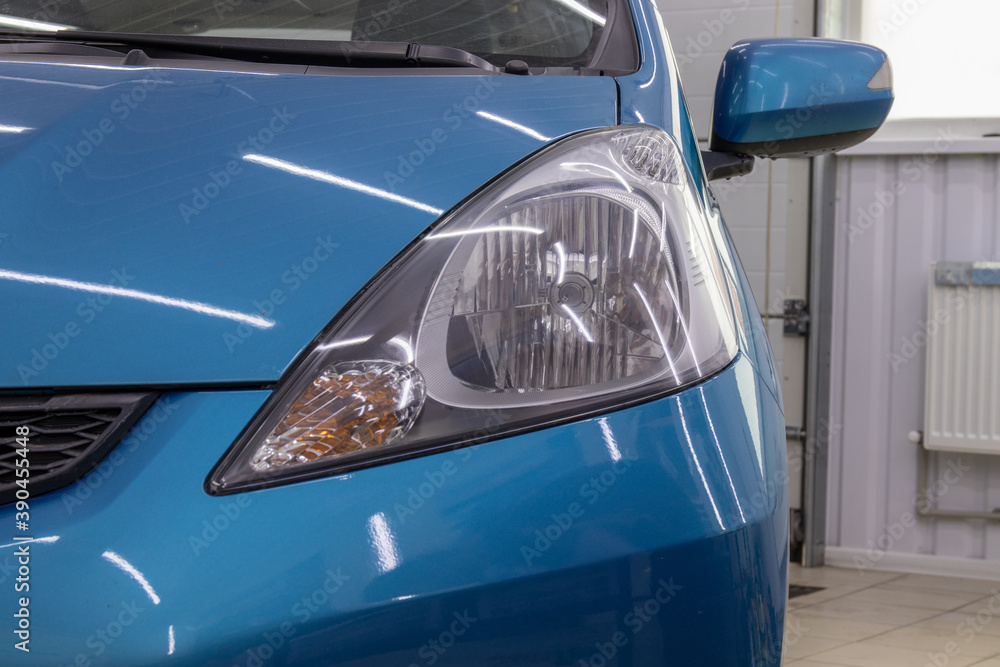 Obraz premium Car headlight after polishing. Car restoration and repair concept. Part of a series.