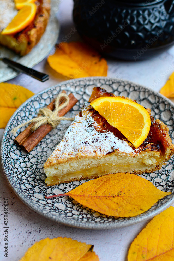 An vertical view of a slice of delicious lemon pie on a serving plate with cinnamon sticks and autumn yellow leaves. Homemade cakes closeup. An vertical view of a slice of delicious lemon pie on a serving plate with cinnamon sticks and autumn yellow leaves. Homemade cakes closeup.