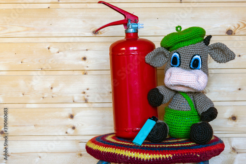 Handmade amigurumi doll goby with a fire extinguisher. Background from the board. photo
