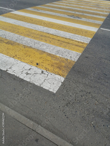 crosswalk. yellow and white stripes on the asphalt © LiliyaDzyba