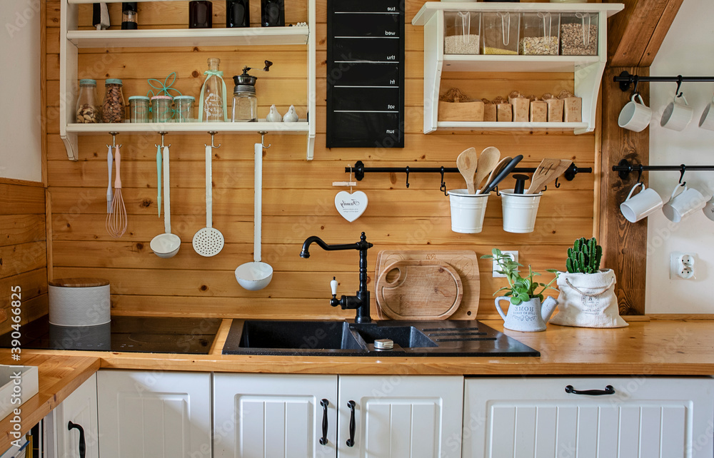 Interior of kitchen in rustic style with vintage kitchen ware and wooden  wall. White furniture and wooden decor in bright cottage indoor. foto de  Stock | Adobe Stock