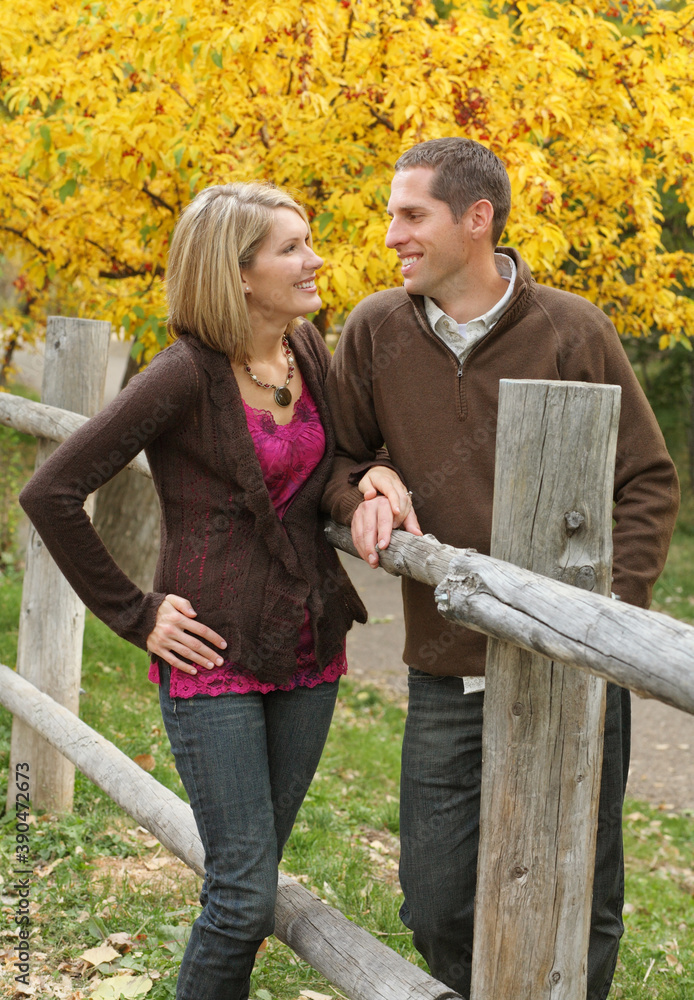 attractive young couple standing together outdoors and looking at each other attractive young couple standing together outdoors and looking at each other