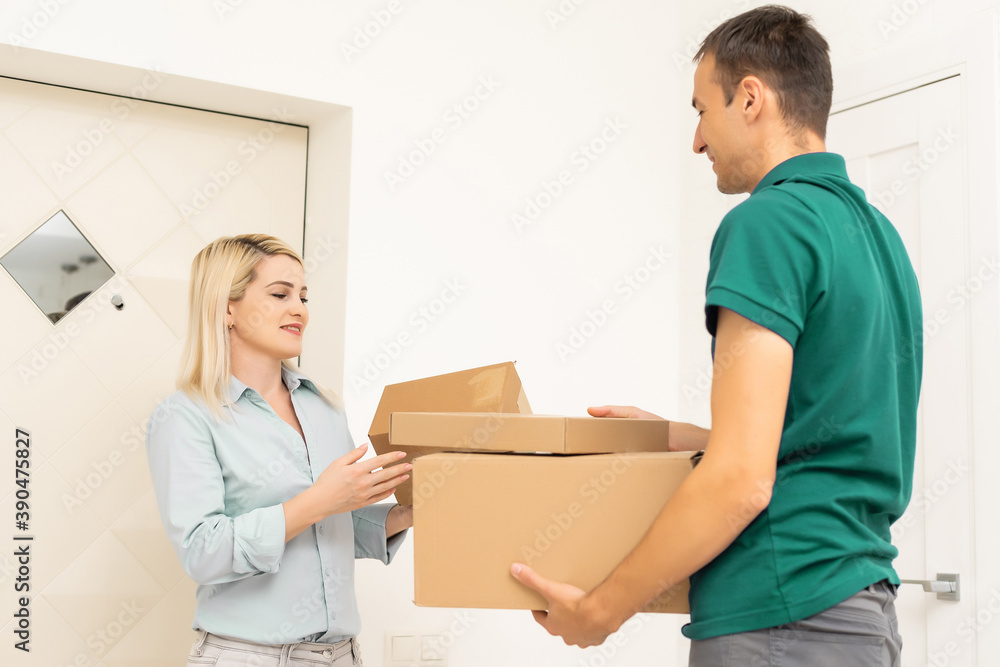 Smiling delivery man giving boxes to woman customer at home for online shopping service concept Smiling delivery man giving boxes to woman customer at home for online shopping service concept