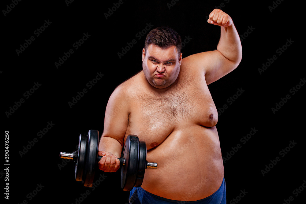 Fat man doing workout traning with dumbbells. Happy guy isolated over yellow background.