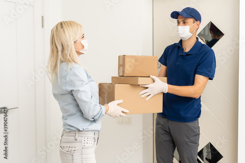 Woman and courier during order transfer. Woman accepting delivery from deliveryman. Cropped image of delivery service worker giving parcel to client. © Angelov