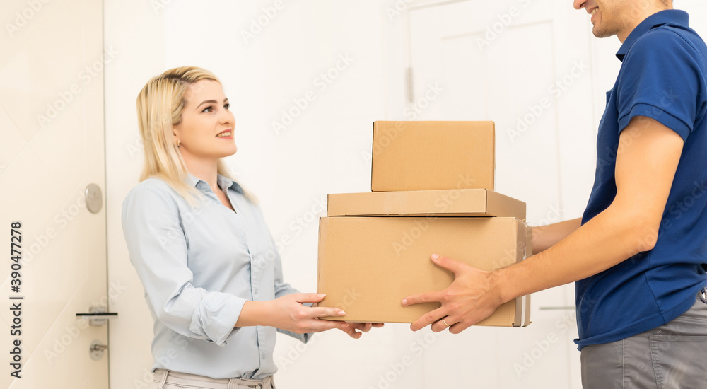 Smiling delivery man giving boxes to woman customer at home for online shopping service concept Smiling delivery man giving boxes to woman customer at home for online shopping service concept