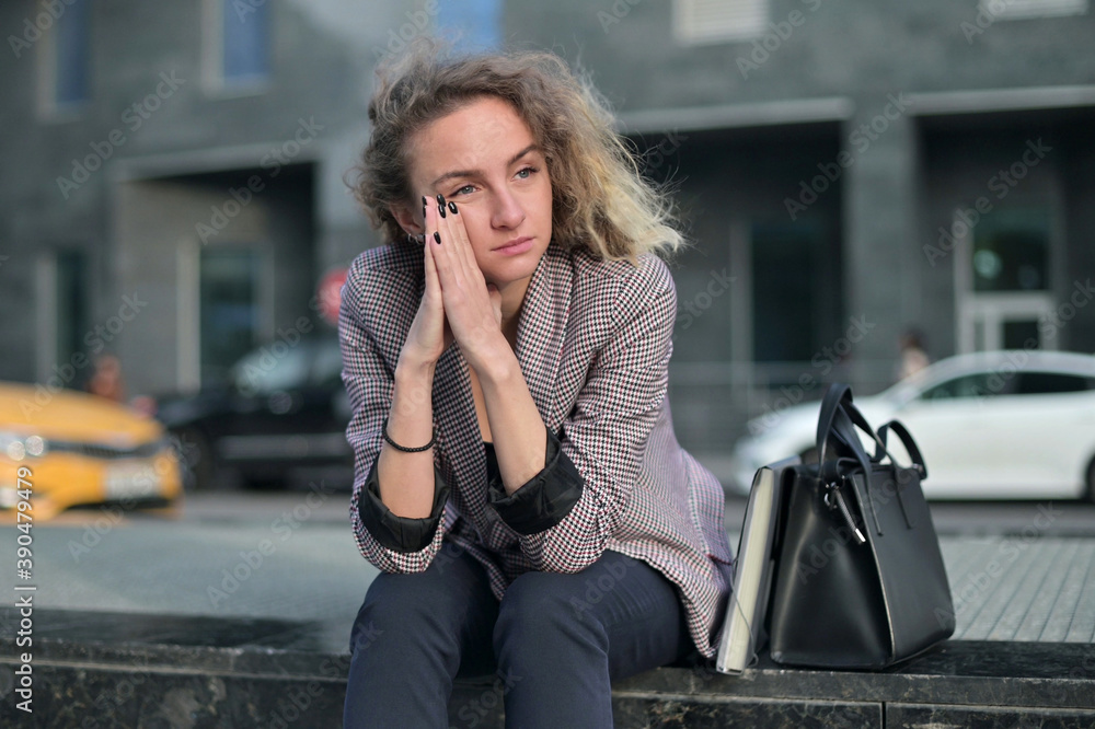 Fototapeta premium office worker, woman, sitting upset after work. She was laid off from her job