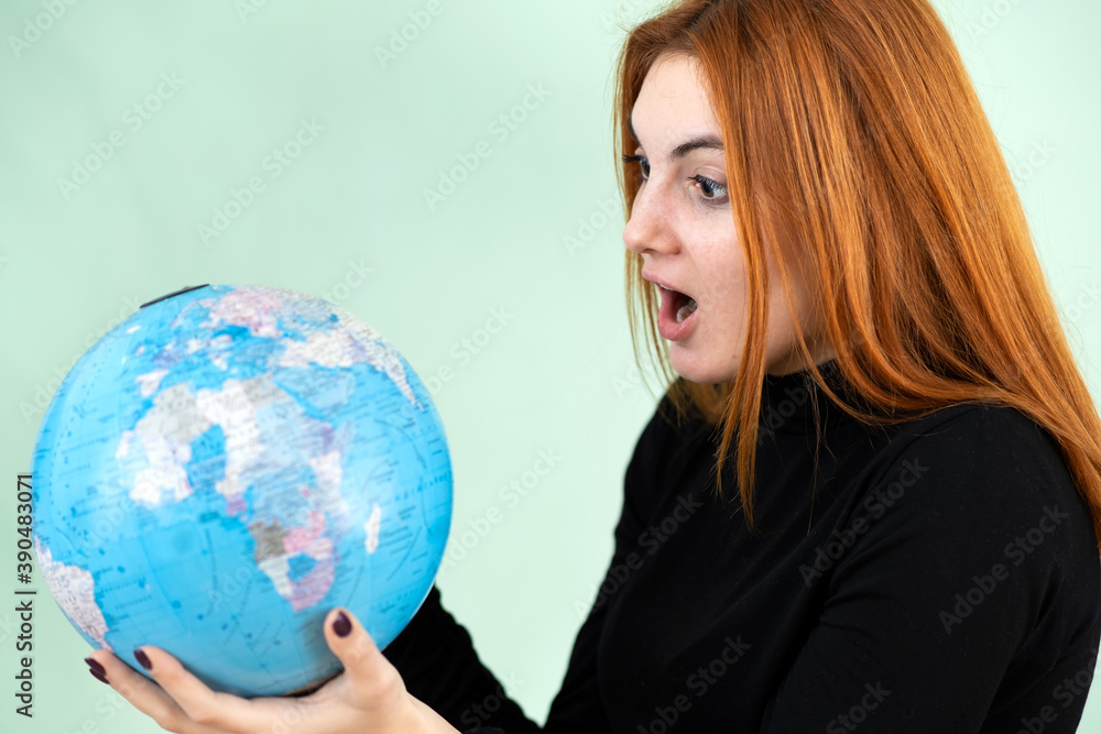 Portrait of a sad worried young woman holding geographic globe of the world in her hands. Travel destination and planet protection concept. Portrait of a sad worried young woman holding geographic globe of the world in her hands. Travel destination and planet protection concept.