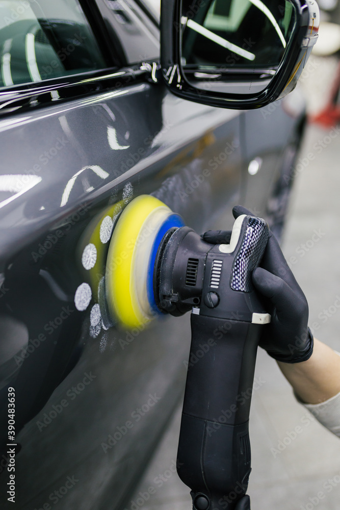Car detailing - Worker with orbital polisher in auto repair shop. Car detailing - Worker with orbital polisher in auto repair shop.
