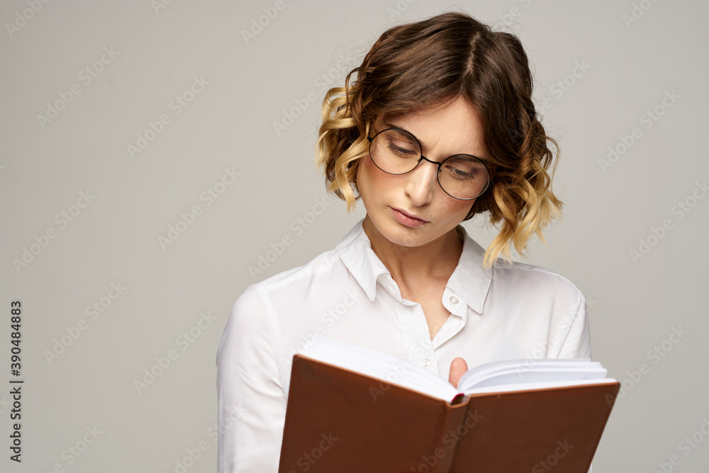 Business woman with notepad and glasses on a light background hairstyle success emotions Business woman with notepad and glasses on a light background hairstyle success emotions