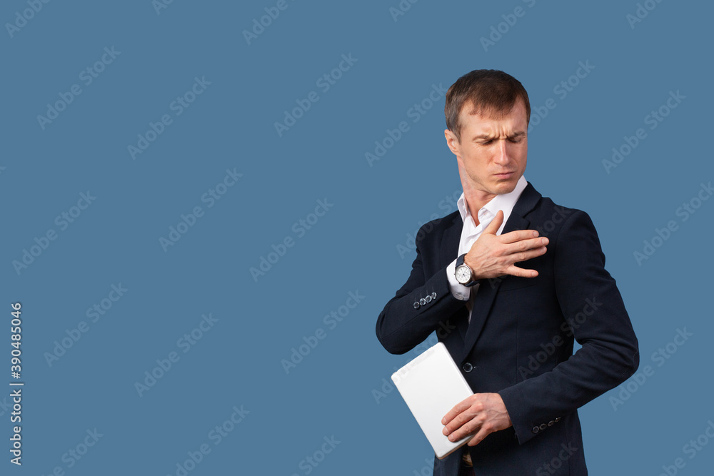 An arrogant male businessman in a suit shakes the dust off his clothes and shoulder with contempt. Studio shot on a blue background. An arrogant male businessman in a suit shakes the dust off his clothes and shoulder with contempt. Studio shot on a blue background.