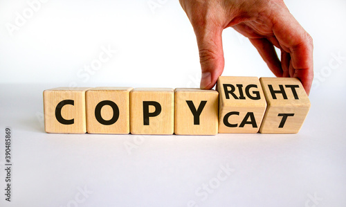 Hand flips cubes and changes the word 'copycat' to 'copyright'. Beautiful white background. Business concept. Copy space. photo