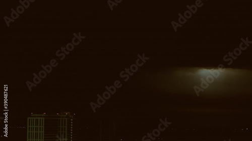 The storm with lighnings above city at night photo