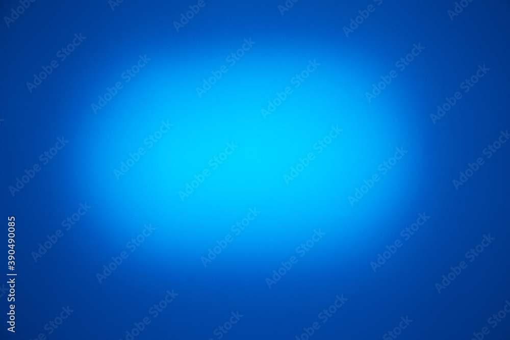 On a blue background, a light blue oval cloud of light On a blue background, a light blue oval cloud of light