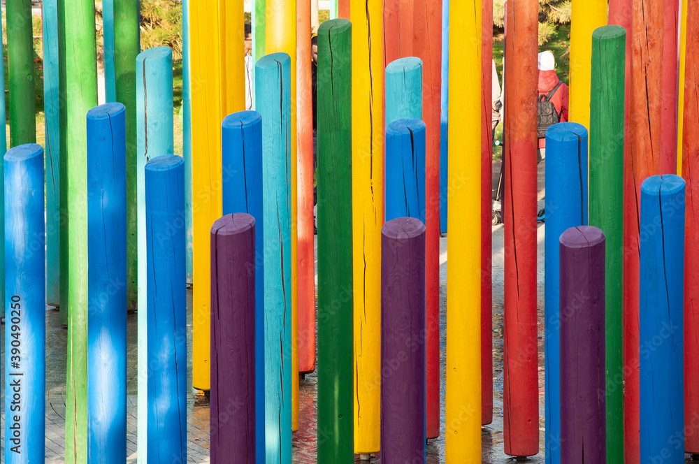 lumber painted in rainbow colours stands vertically on the playground - obrazy, fototapety, plakaty 