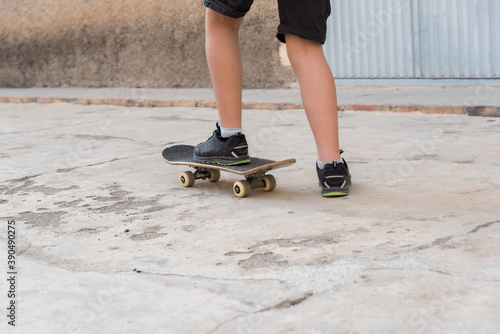 Close-up view from behind a young man riding his skateboard.