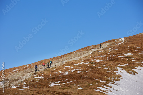 Tourists with backpacks in the High Tatras mountains on their way to Kopa Kondracka. Czerwone Wierchy, Poland