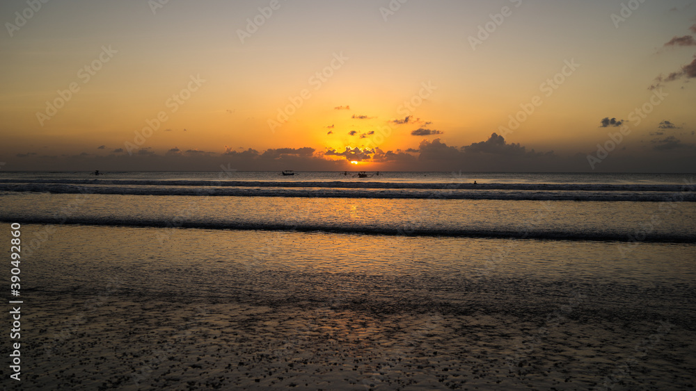 Beautiful golden sunset over the sea in Kuta beach, Bali Island, Indonesia. Freedom and spirituality concept, meditation on the beach, beautiful destination