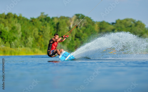 Wakeboarder surfing across a lake © Mark_studio