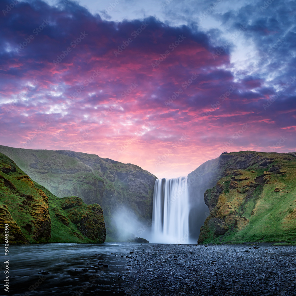 Famous Skogafoss waterfall on Skoga river in sunset time. Iceland, Europe. Great purple sky glowing on background. Landscape photography