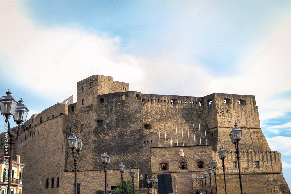 The fort of Castl dell' Ovo in Naples, Italy, towering over the bay of Naples with the Vesuvius volcano in the distance