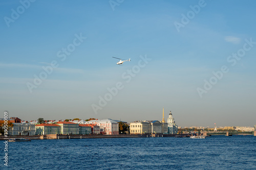 White helicopter over the blue river. Saint Petersburg.
