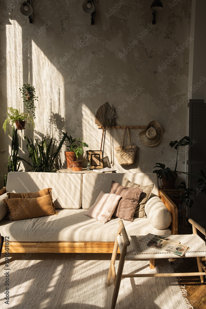 Warm boho style modern home interior design, Sofa, pillows, home plants,  carpet and decorations against concrete wall, foto de Stock | Adobe Stock
