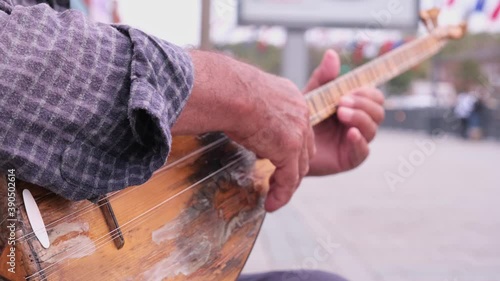 Playing baglama Turkish string music instrument. An old and worn-out music instrument photo