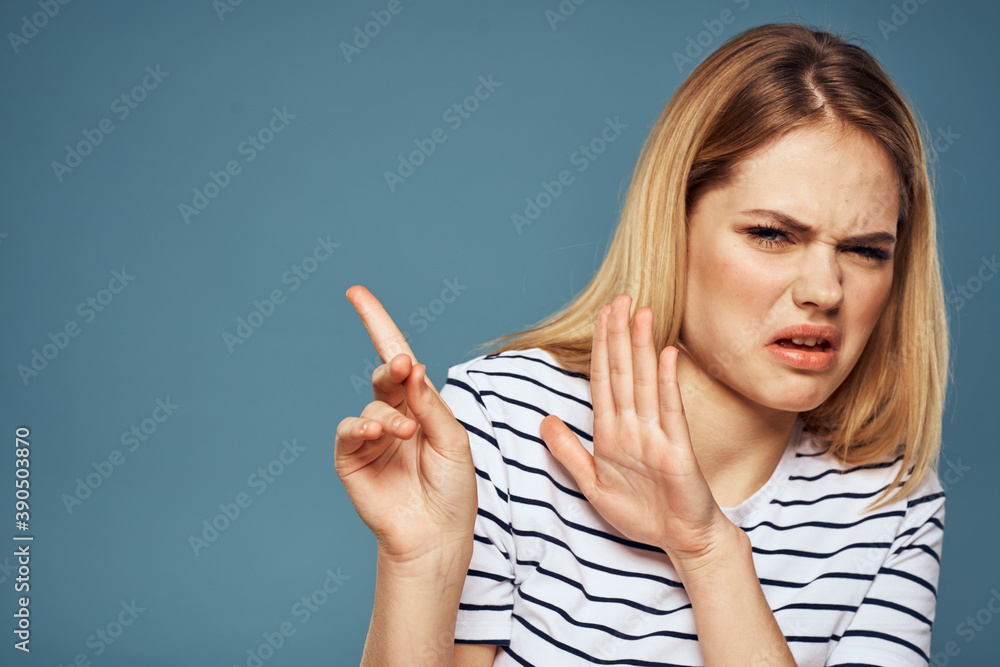 woman wearing striped t-shirt cropped view blue isolated background displeased facial expression woman wearing striped t-shirt cropped view blue isolated background displeased facial expression