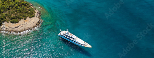 Aerial drone ultra wide photo of luxury yacht with wooden deck anchored in tropical exotic island bay wit turquoise sea © aerial-drone