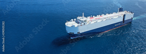 Aerial drone ultra wide photo of huge car carrier ship RO-RO (Roll on Roll off) cruising in Mediterranean deep blue Aegean sea